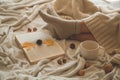 Cozy Autumn winter evening , warm woolen socks. Woman is lying feet up on white shaggy blanket and reading book. Royalty Free Stock Photo