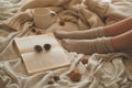 Cozy Autumn winter evening , warm woolen socks. Woman is lying feet up on white shaggy blanket and reading book Royalty Free Stock Photo