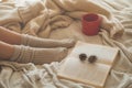 Cozy Autumn winter evening , warm woolen socks. Woman is lying feet up on white shaggy blanket and reading book Royalty Free Stock Photo