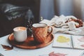 Cozy autumn or winter morning at home. Still life details with cup of tea, candle, sketch book with herbarium and warm sweater Royalty Free Stock Photo