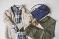 cozy autumn woman casual outfit set flat lay. Plaid shirt, knitted sweater, blue cross body bag and khaki pants Royalty Free Stock Photo