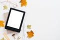 Cozy autumn workspace. Home office desk table with ebook mockup, maple leaves and glasses on white. Flat lay, top view, copy space