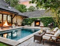 Cozy backyard or patio area with garden furniture, swimming pool and outdoor fireplace Royalty Free Stock Photo