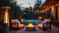 Cozy backyard patio with pool, fireplace heater, string lights, chairs. Evening relaxation setting with candles on coffee table Royalty Free Stock Photo