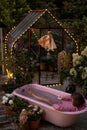 Cozy backyard with a woman bathing in pink bathtub Royalty Free Stock Photo