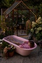 Cozy backyard with a woman bathing in pink bathtub Royalty Free Stock Photo