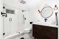 A cozy bathroom with a dark wood cabinet and mosaic tile flooring.