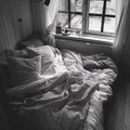 Â Cozy bed with monochrome bedding. Royalty Free Stock Photo