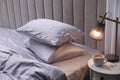 Cozy bed with soft silky bedclothes in light room