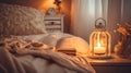 Cozy bedroom ambiance with an open book, a lit candle lantern, and a vase of dried flowers on a bedside table, inviting