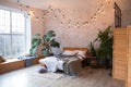 Cozy bedroom area at luxury studio apartment with a free layout in a loft style with big panoramic window and green Royalty Free Stock Photo