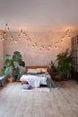 Cozy bedroom area at luxury studio apartment with a free layout in a loft style with big panoramic window and green Royalty Free Stock Photo