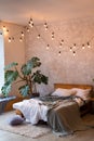 Cozy bedroom area at luxury studio apartment with a free layout in a loft style with big panoramic window and green Royalty Free Stock Photo