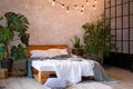 Cozy bedroom area at luxury studio apartment with a free layout in a loft style with big panoramic window and green Royalty Free Stock Photo