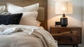 Cozy bedroom detail with soft bedding and wooden nightstand Royalty Free Stock Photo