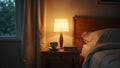 Cozy bedroom with dimly lit bedside lamp books and tea Royalty Free Stock Photo