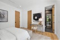 Cozy bedroom interior featuring a single bed and a dresser, with a large window