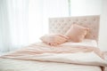 Cozy bedroom interior, Large bed by the window in pastel colors Royalty Free Stock Photo