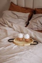 Cozy bedroom with unmade bed and breakfast on a tray. Royalty Free Stock Photo