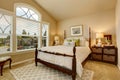 Cozy Beige bedroom with vaulted ceiling and elegant Victorian style bed.