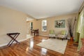 Cozy beige sitting room with shiny hardwood floor and dining area