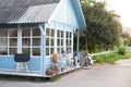 Cozy blue home with a beautiful garden in summer. Beautiful farmhouse with wicker baskets and green plants on terrace. White table Royalty Free Stock Photo