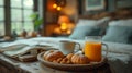 A cozy breakfast on a bed on a wooden round tray with a cup of coffee, orange juice and pastry with nuts