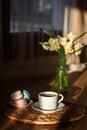 Cup of coffee on wooden table, vase with flowers. Royalty Free Stock Photo