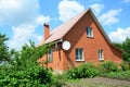 Cozy brick house with antenna and metal roof Royalty Free Stock Photo