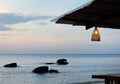 Cozy cafe with bamboo lamps on the beach at the beautiful sunset. Royalty Free Stock Photo
