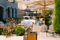 Cozy cafe in Lustica Bay, Montenegro. Wicker furniture with striped pillows, parasols and a retro car. Royalty Free Stock Photo