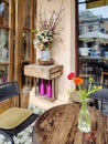 Cozy cafe, wooden table with flowers. Exterior of the cafe restaurant, outdoor table. Decor facade of coffeehouse, vintage style