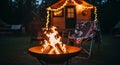 Cozy campsite scene with crackling fire and string lights on a small cabin at night Royalty Free Stock Photo