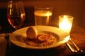 Cozy candlelit dinner setting with egg and beverages Royalty Free Stock Photo