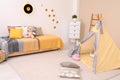 Cozy child room interior with bed, play tent