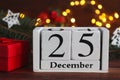 Cozy Christmas composition with calendar dated 25 December, Christmas tree, and gift box. Selective focus, close-up