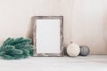 Cozy Christmas home decor. Empty portrait frame mockup, fir branch and vintage christmas balls. White wood table and shabby Royalty Free Stock Photo