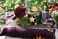 Cozy Christmas still life with paper ornament and green jar candle on woolen sweater