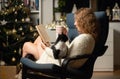cozy Christmas time at home woman with cat reading a book hygge Royalty Free Stock Photo