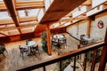 Cozy coffee shop with tables in the attic. Wood interior decorated with plants Royalty Free Stock Photo