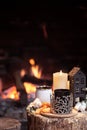 Cozy composition with a cup, candle and tangerines on a stump near the fireplace copy space Royalty Free Stock Photo