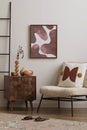 Cozy composition of living room interior with mock up painting frame, boucle armchair, pillow, wooden coffee table, ladder, Royalty Free Stock Photo