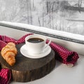 A cozy concept. Classic winter breakfast. A cup of coffee and a croissant stand on the windowsill Royalty Free Stock Photo