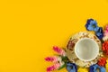 Cozy concept, yellow isolated background, tea party set with flowers, top view and copy space, border Royalty Free Stock Photo