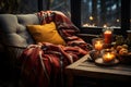 A cozy country scene near the window featuring a warm blanket, pillow and a mug of hot beverage