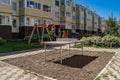 Cozy courtyard between houses with green plants and attractions for children. A wonderful space for outdoor recreation