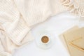 Cozy cream blanket on white bed with gold and natural notebooks, and espresso