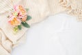 Cozy cream blanket on white bed with pink and peach flowers