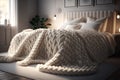 Cozy cream colored woolen blanket on king size bed in bright bedroom Royalty Free Stock Photo