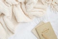 Cozy cream blanket on white bed flatlay with neutral notebooks and gold pen